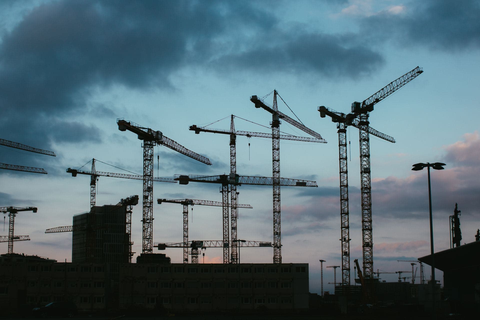 Baustelle mit Kränen in der Abenddämmerung