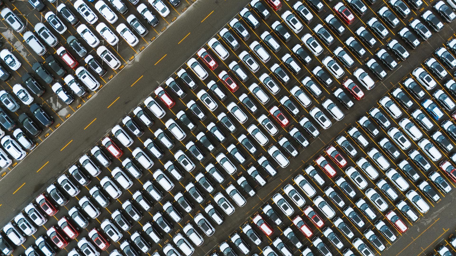 Fahrzeuglager aus der Luft mit Hunderten Fahrzeugen in diagonalen Reihen